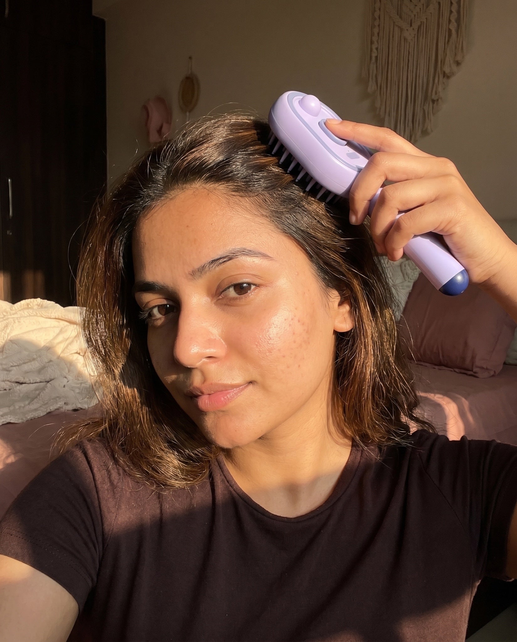Woman using the Lavender Cloud scalp massage brush at home