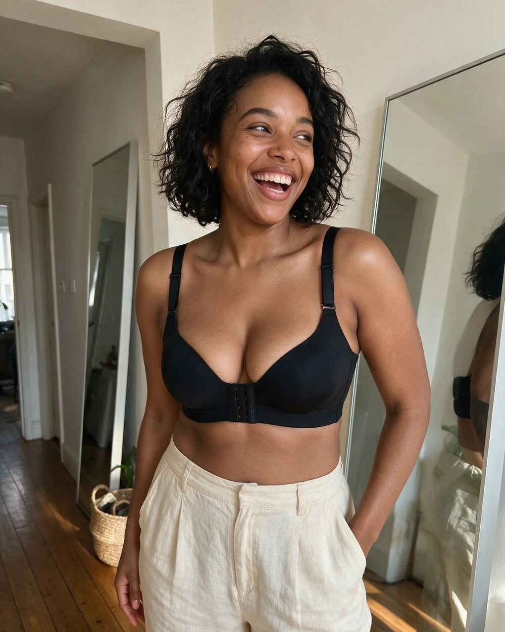 A woman laughing while buttoning a shirt over The Ease wireless smoothing bra in Black