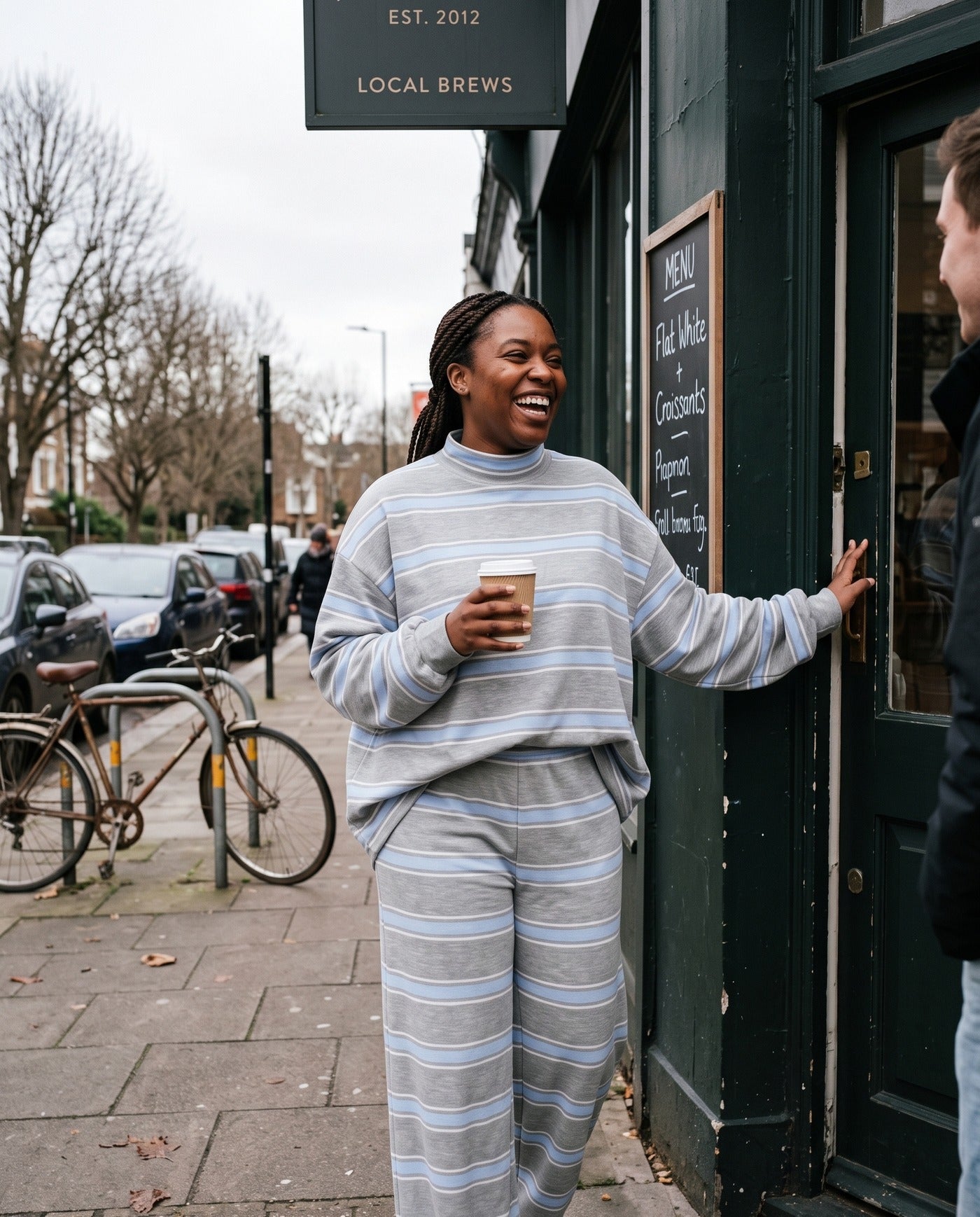 A woman leaving a coffee shop in The Sunday striped lounge set